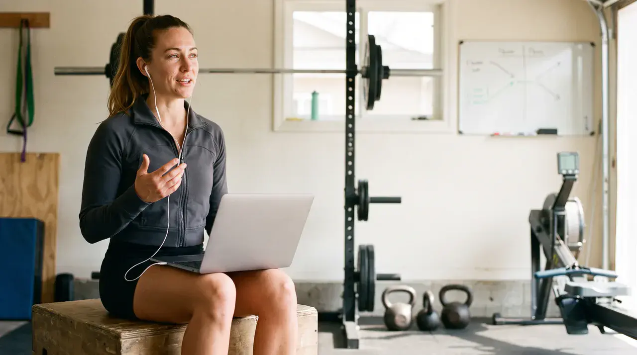 Business coach for fitness professionals on a coaching call from her home gym